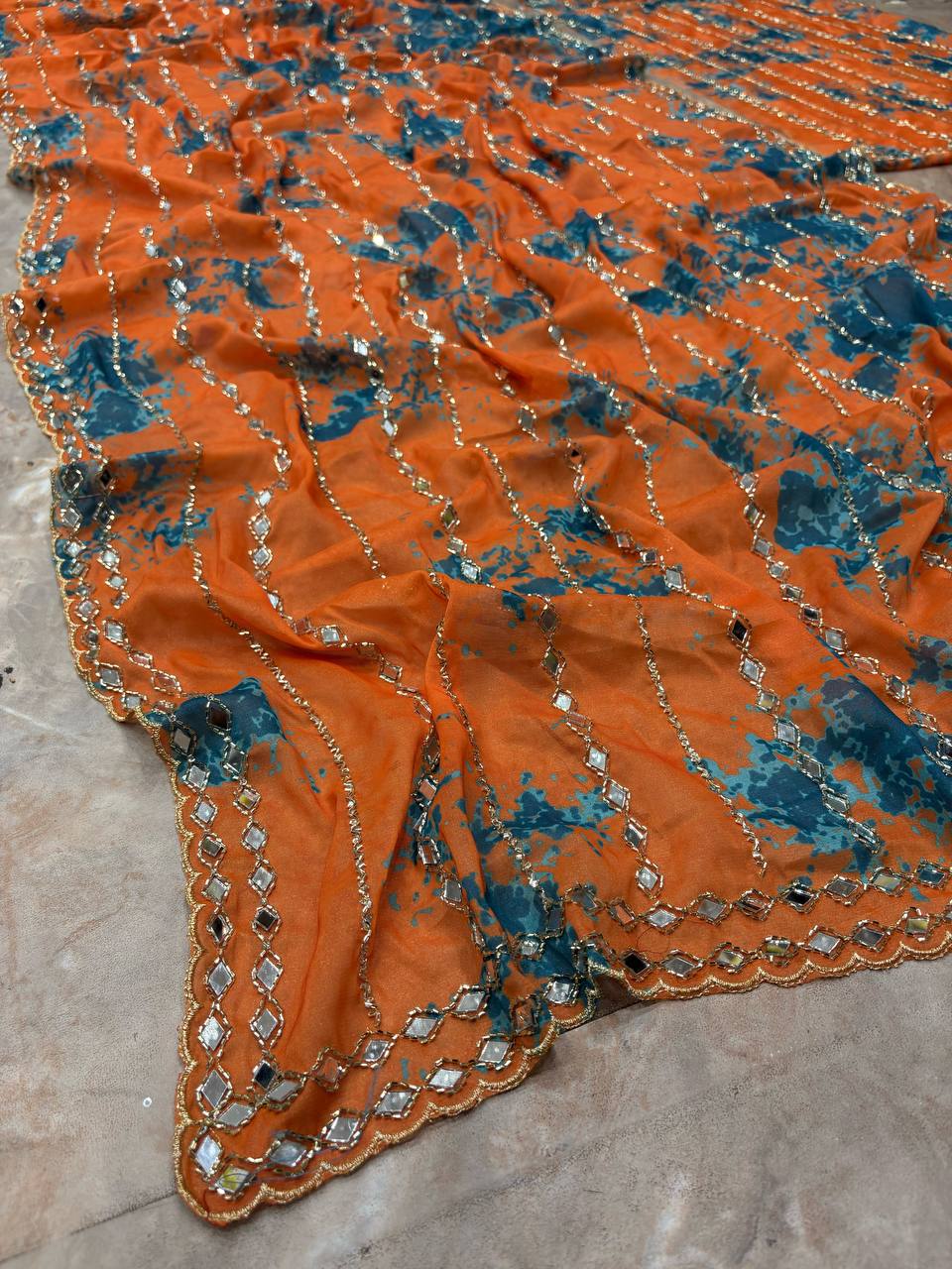Close-up of orange saree mirror embellishments and border