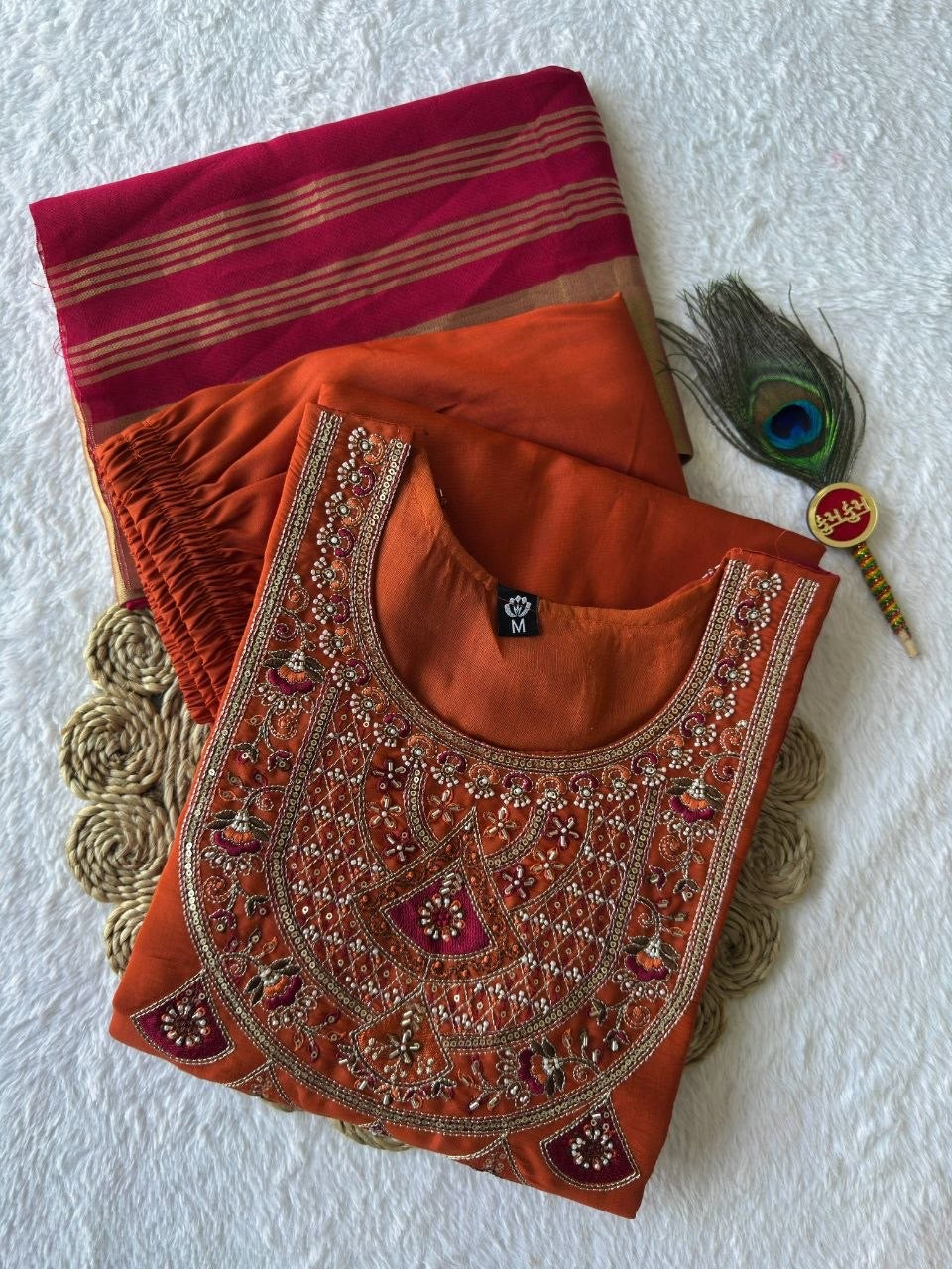 Rust kurta set and fuchsia dupatta with gold border flat lay