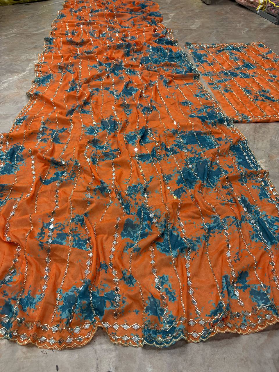 Model wearing orange and blue Premium Star Georgette digital print saree with real mirror and beads work